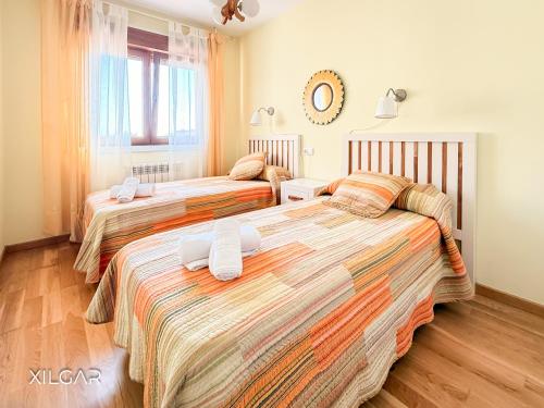 a bedroom with three beds with white towels on them at Xilgar - O Vimbieiro Chalet in Sanxenxo