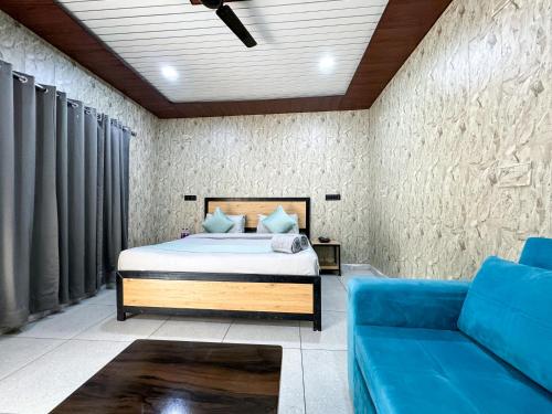 a bedroom with a bed and a blue couch at Euphoric Resort ,Mohanchatti in Rishīkesh