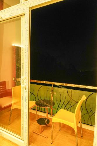 a room with chairs and a table and a large window at Le Karaj Meadows in Lovedale