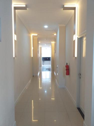an empty hallway with white walls and a long hallway at Daima Syariah Mansion in Jakarta