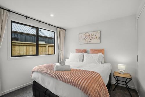 a bedroom with a large bed and a window at Mountain Escape by Remarkables 9 | 2-bedroom unit in Frankton Wharf
