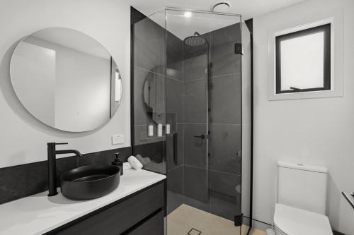 a bathroom with a sink and a shower with a mirror at Mountain Escape by Remarkables 9 | 2-bedroom unit in Frankton Wharf