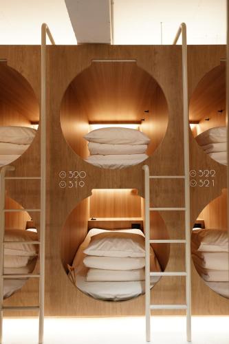 a room with wooden bunk beds with white pillows at D A L Premium Capsule Hotel in Seoul
