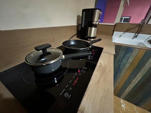 deux casseroles et poêles sur une cuisinière dans une cuisine dans l'établissement Independencia 106 - Una casa cómoda en el centro historico de Oaxaca, à Oaxaca