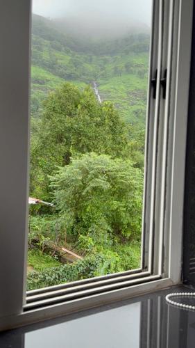 a window with a view of a lush green field at Prana Healing House in Pune