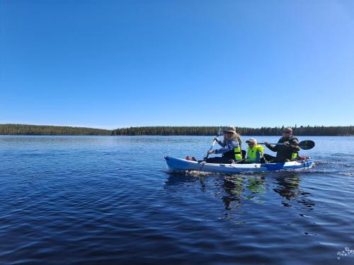 a group of people in a kayak on a lake at WOLF Lakeside Cabins Lapland in Rovaniemi