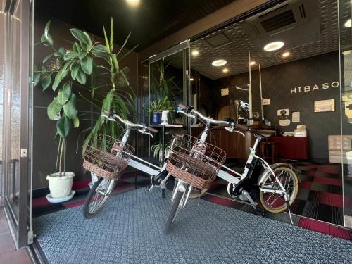 two bikes are parked in a room with plants at Hibaso in Shōbara