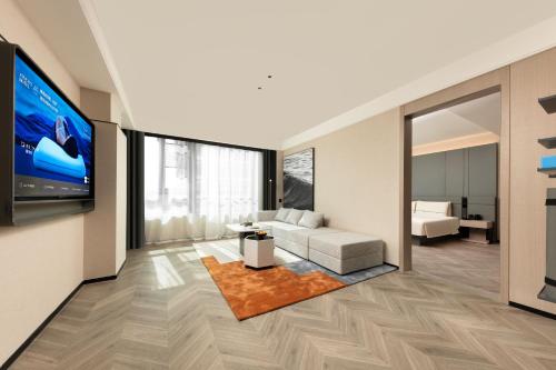 a living room with a couch and a tv at Atour S Hotel Xiamen Gaoqi Airport Huli District Government in Xiamen