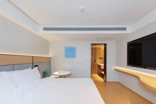 a bedroom with a large bed and a flat screen tv at JI Hotel Beijing Liuliqiao East Subway Station in Beijing