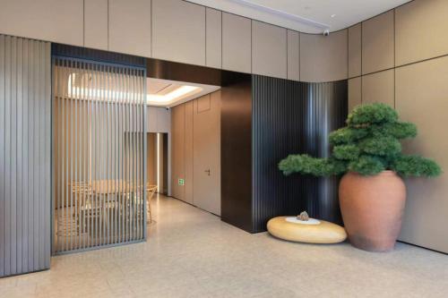 a large vase with a plant in a hallway at JI Hotel Beijing Liuliqiao East Subway Station in Beijing