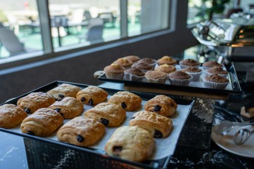 a bunch of pastries on trays on a table at VOGO Grand Hotel Formerly Best Western Plus Hotel Dubai Academic City in Dubai