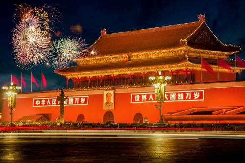 a chinese building with fireworks in the background at Yinzhuo Hotel - New Chinese decoration, free late-night supplies, free fruit, water and free snacks, close to the International Convention and Exhibition Center, Embassy, Sanlitun, Bird's Nest, close to Sanyuan Bridge of Metro Line 10 and Airport Line in Beijing