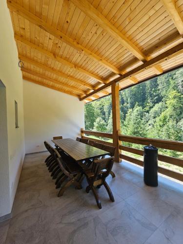 ein Tisch und Stühle in einem Raum mit einem großen Fenster in der Unterkunft Vila veverita in Schitu-Tarcău