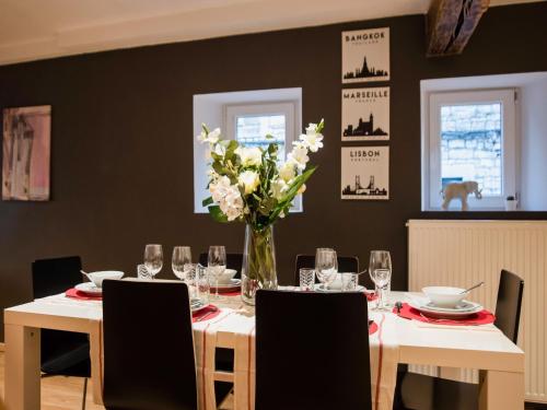 a dining room with a table with a vase of flowers at Holiday home in the centre of Aywaille in Aywaille