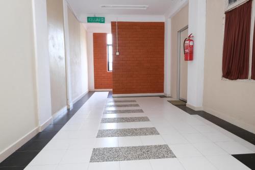 a hallway with a red door and a white tile floor at OYO 1017 Al-inshirah Inn in Kota Bharu