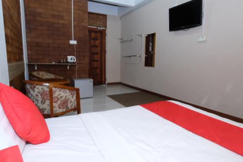 a bedroom with a bed and a tv on the wall at OYO 1017 Al-inshirah Inn in Kota Bharu