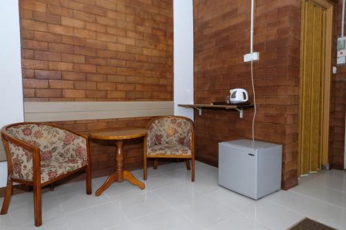 a table and two chairs in a room at OYO 1017 Al-inshirah Inn in Kota Bharu