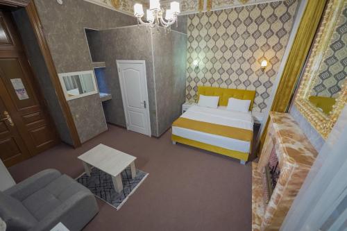 a bedroom with a bed and a chair and a couch at Nizami Hotel Baku in Baku