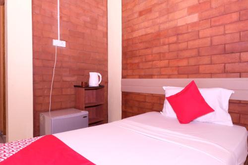 a bedroom with a bed with red and white pillows at OYO 1017 Al-inshirah Inn in Kota Bharu