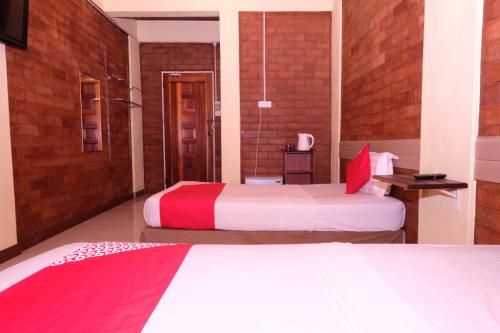 a hotel room with two beds with red and white sheets at OYO 1017 Al-inshirah Inn in Kota Bharu