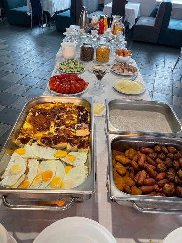 a table with several trays of food on it at Alex Hotel in Kohtla-Järve