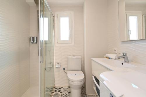 ein Badezimmer mit Toilette und Glasdusche in der Unterkunft Hawaii in Jávea