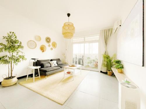 a living room with a couch and a table at Gongxi Home Plus Bell Tower Big Wild Goose Pagoda Tangcheng Terra Cotta Warriors6 metro away from Xian North Railway Station 3 minutes walk to Line 2 100 inch projection free trial service in Xi'an