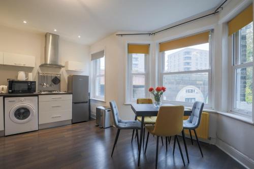 a kitchen and dining room with a table and chairs at Stylish Home - Ten Mins to Central London in London