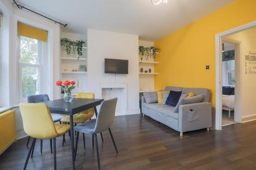 a living room with a table and a couch at Stylish Home - Ten Mins to Central London in London