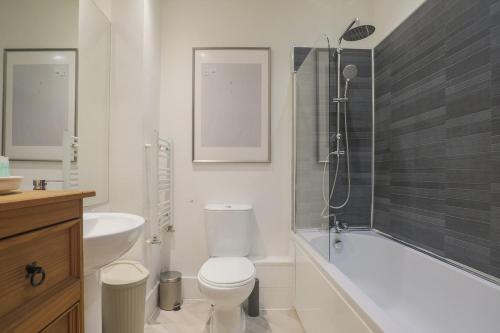 a bathroom with a toilet and a sink and a shower at Stylish Home - Ten Mins to Central London in London