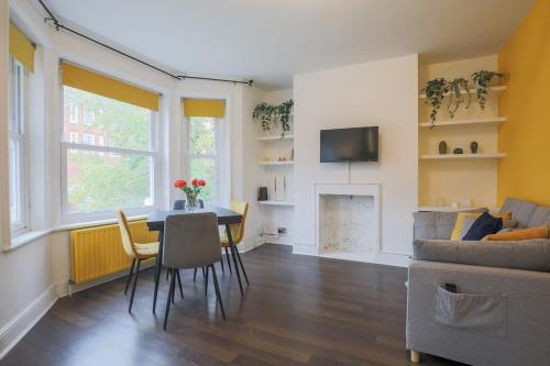 a living room with a table and a couch at Stylish Home - Ten Mins to Central London in London