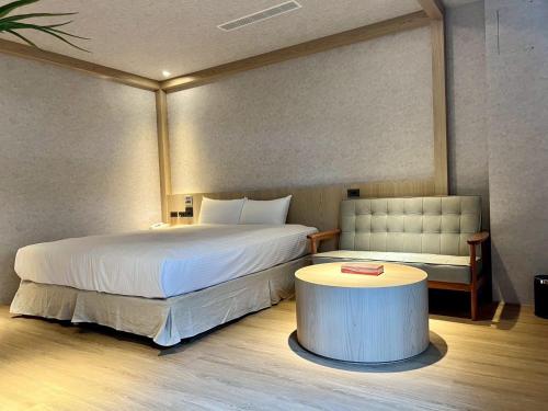 a bedroom with a large bed and a table at Fairy Tale City Motel in Hualien City
