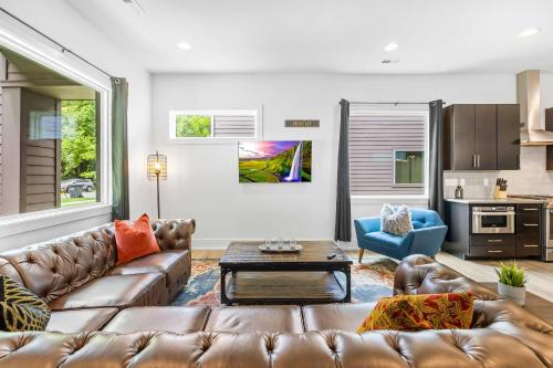 a living room with a leather couch and a table at Modern new 4BR Home near NoDa & Downtown in Charlotte