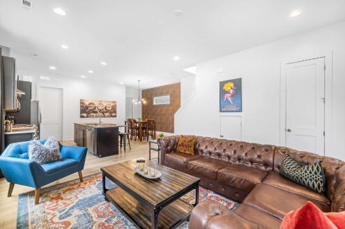 a living room with a brown leather couch and a table at Modern new 4BR Home near NoDa & Downtown in Charlotte