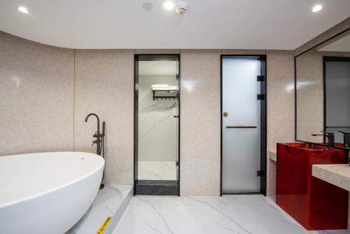 a bathroom with a white tub and a toilet at Leshan Manfu Hotel in Leshan