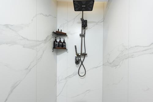 a white tiled bathroom with a shower with a toothbrush at Leshan Manfu Hotel in Leshan
