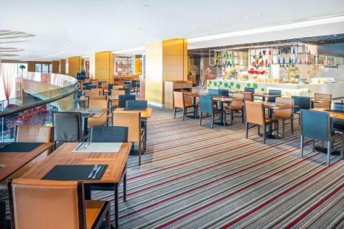 a dining room with tables and chairs in a restaurant at Holiday Inn Tianjin Riverside by IHG in Tianjin
