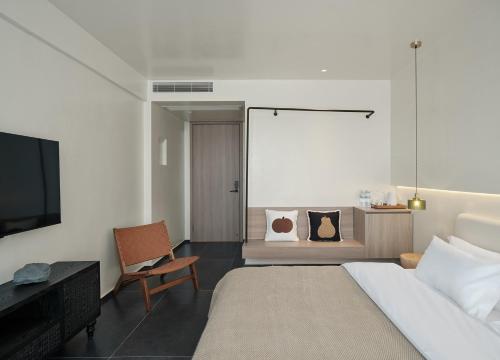 a bedroom with a bed and a desk and a tv at 涠洲岛隐拙山与澜海景酒店 in Weizhouxu