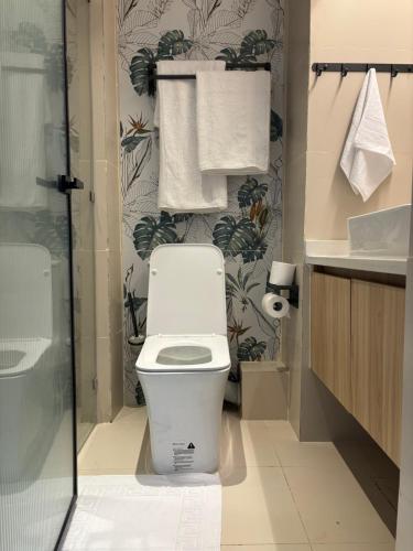 a bathroom with a toilet and a sink and towels at Modern studio near the Airport with Gym and Pool in Nairobi
