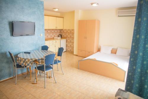 a bedroom with a bed and a table and chairs at Elite Apartments in Sunny Beach