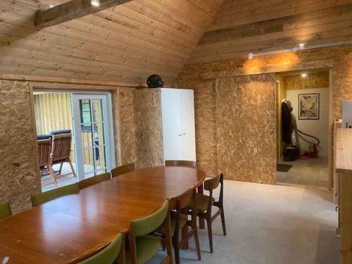 a large wooden table and chairs in a room at Holiday On Magical Nature Plot For Families in Hadsund
