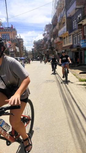 a group of people riding bikes down a street at Udaya Home Stay in Panauti