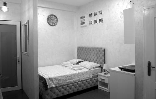 a bedroom with a bed and a clock on the wall at Apartman 11550 in Lazarevac