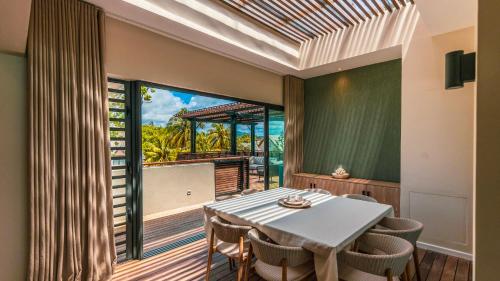 a dining room with a table and chairs and a balcony at Blue Nest by Horizon Holidays in Pointe d'Esny
