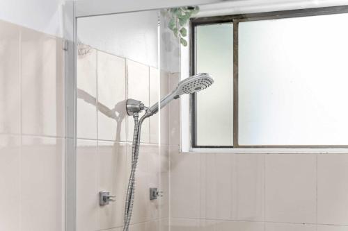 a shower with a shower head in a bathroom at Double Room in Peakhurst - Centrally Located - Shared Bathroom in Peakhurst