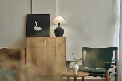 a living room with a chair and a lamp at 涠洲岛隐拙山与澜海景酒店 in Weizhouxu