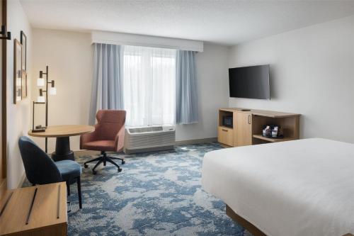 a hotel room with a bed and a desk and a table at Hampton Inn & Suites Jekyll Island in Jekyll Island