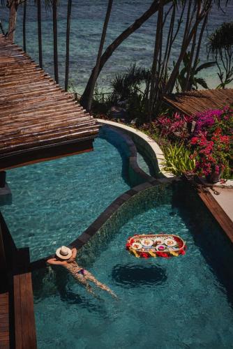 a swimming pool with a pizza in the water at NIHI Sumba - 50 Best Hotels of the World in Watukarere