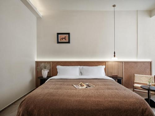 a bedroom with a large bed and a chair at 涠洲岛隐拙山与澜海景酒店 in Weizhouxu
