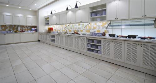 a large kitchen with white cabinets and tile floors at Hyatt Place Ocean City Oceanfront in Ocean City